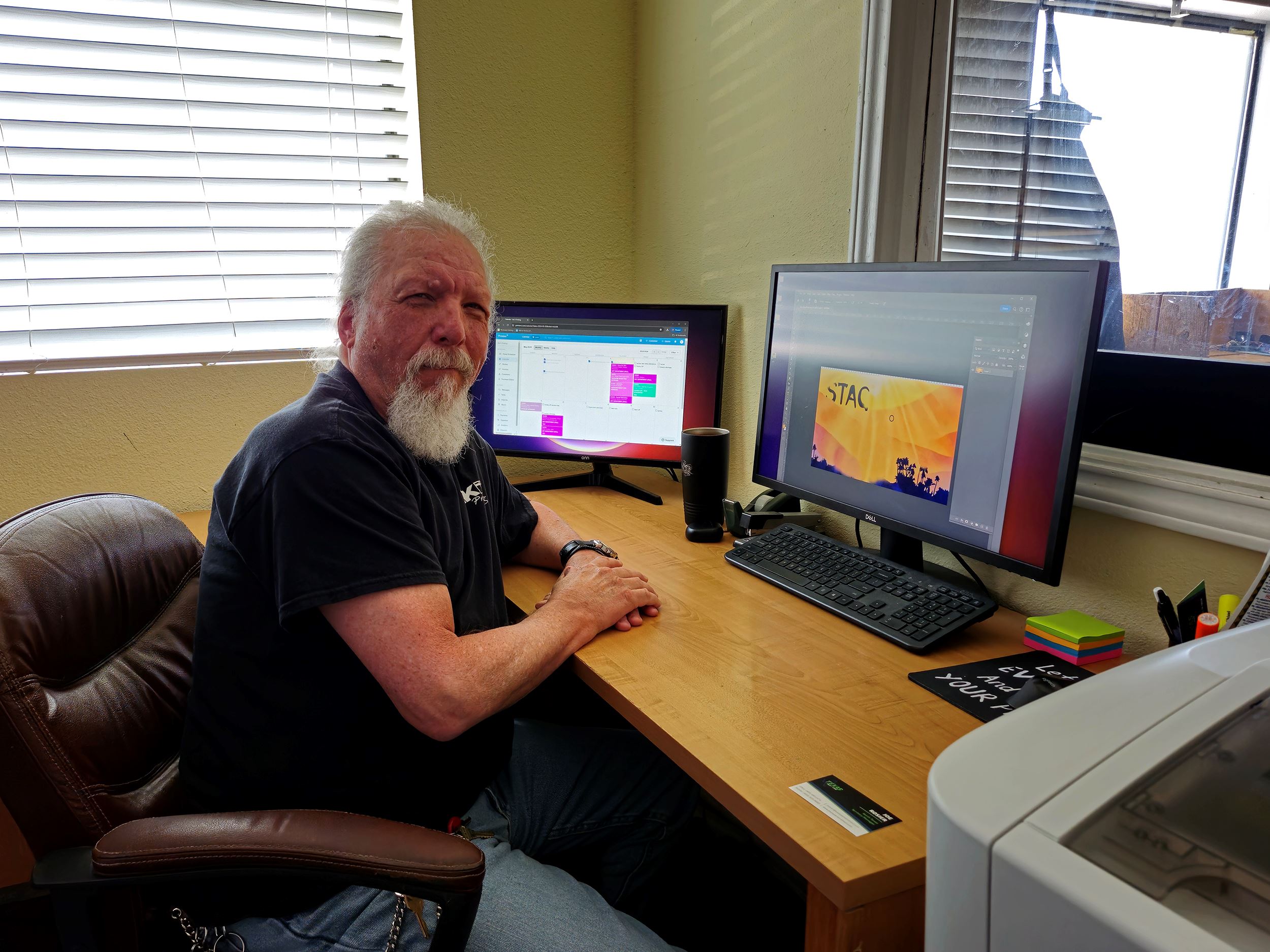 Graphic Designer sitting in front of computer smiling at camera