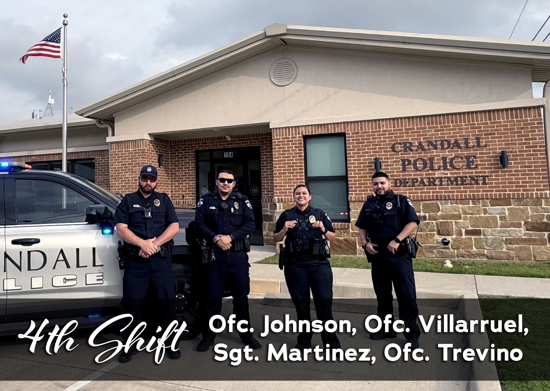 4th patrol shift standing by police SUV in front of police station