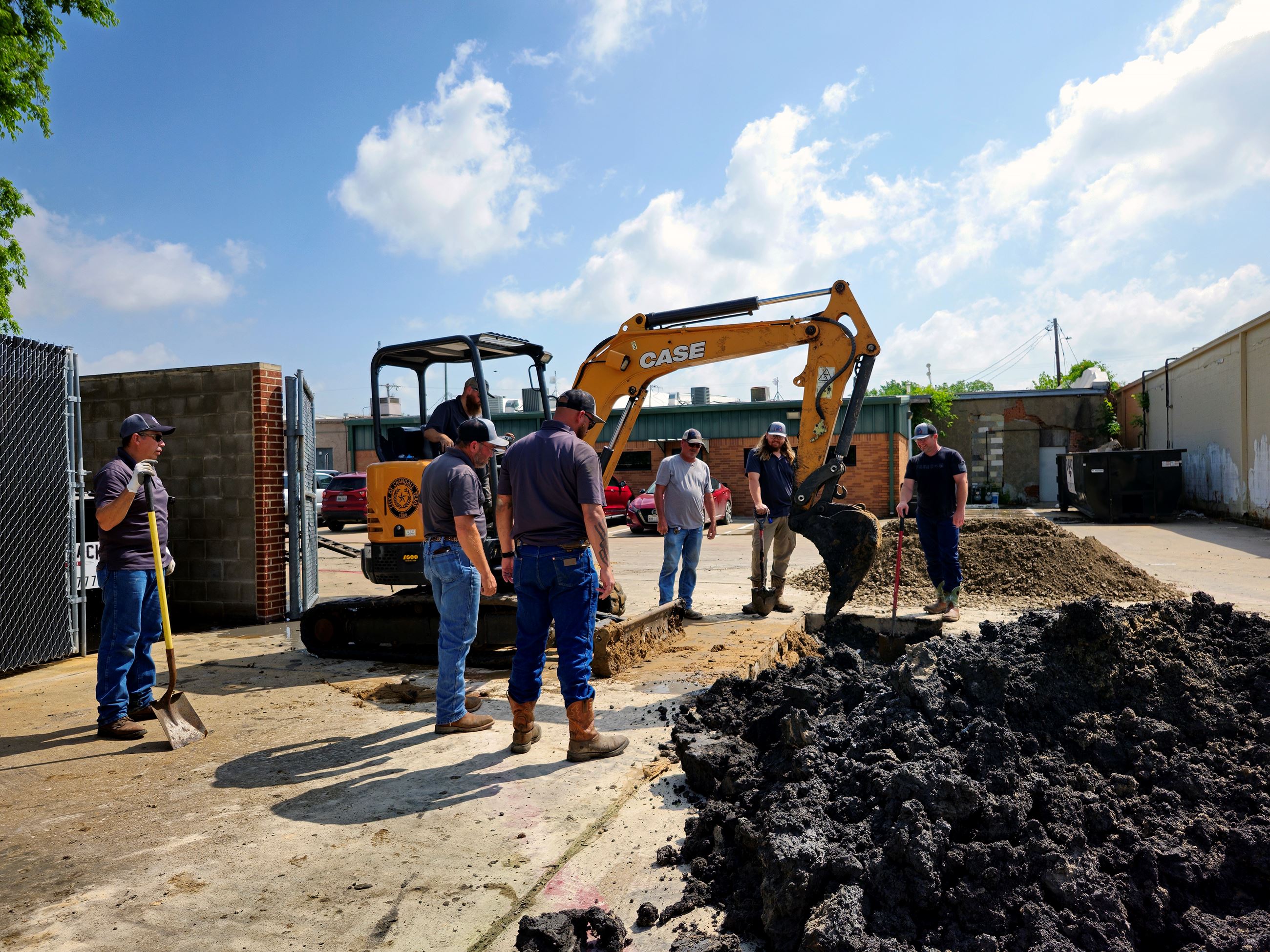 Public Works employees fill hole in with dirt